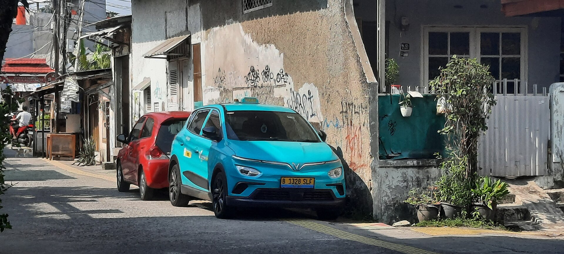 Taxi điện Green SM màu xanh đỗ bên đường chờ đón khách